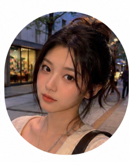 A circular portrait of a young woman with dark hair in a messy bun, wearing a light beige top and a silver chain necklace, set against an outdoor street background at dusk.